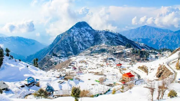 Snow-covered hills and red-roofed houses at Malam Jabba in Swat
